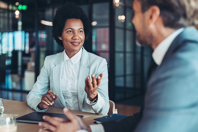 Business lady talking with colleague at table